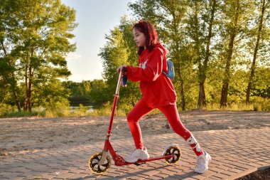 Mobilete binen çocuk. Renkli tekme tahtasında bir çocuk. Çocuklar için açık hava eğlencesi. Çocuklar için spor. Spring Park 'taki küçük mutlu kız. Sağlıklı bir yaşam tarzı. Çevre dostu nakliye aracı. Mobiletli bir genç.