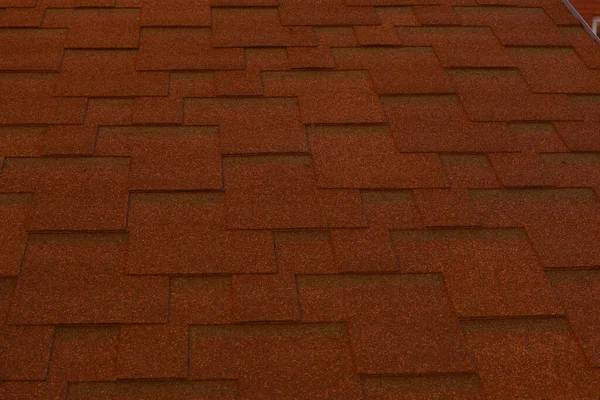 red roof. Metal tile. Part of the house roof as a backdrop for designers. Texture of building material in daylight