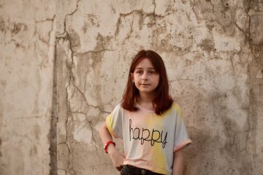 Yazın 9 yaşında bir kız. Yüzünde ciddi bir ifade olan açık renk tişörtlü genç bir kız. Ciddiyet ve düşünceli bir duygu. Karateli bir genç..