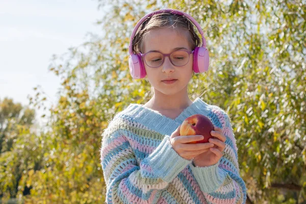 Schoolmeisje Met Rugzak Hoofdtelefoon Het Park Een Schoolmeisje Roze Koptelefoon — Stockfoto