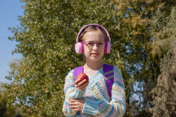 Schoolmeisje Met Rugzak Hoofdtelefoon Het Park Een Schoolmeisje Roze Koptelefoon — Stockfoto