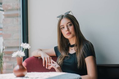 Çok güzel bir bayan keyfine bak ve rahatla. Kafedeki kız. Esmer portresi. Siyah elbise dükkanındaki kız. Genç bir kız beklerken pencereden dışarı bakar. Beklenti. Umut. Güzellik konsepti