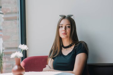 Çok güzel bir bayan keyfine bak ve rahatla. Kafedeki kız. Esmer portresi. Siyah elbise dükkanındaki kız. Genç bir kız beklerken pencereden dışarı bakar. Beklenti. Umut. Güzellik konsepti