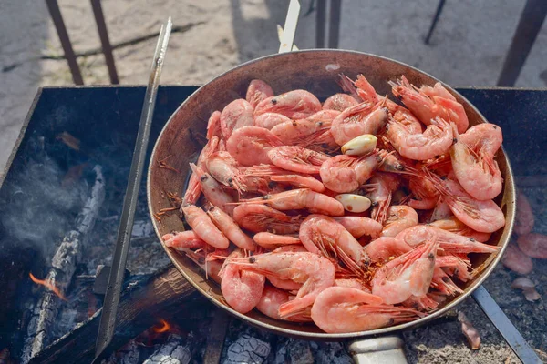 shrimp. Shrimps are cooked in a pan over a fire. Bonfire seafood