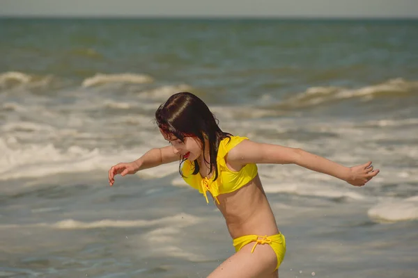 女孩在海上 那年轻姑娘的画像 青少年暑假沙地 阳光灿烂的日子和大海 童年旅行假期 在海滩上穿着黄色泳衣的青少年 青少年在海里游泳 — 图库照片