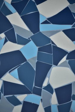 Kaya taşı mavisi, duvardaki çatlak desenli simetri dekorasyonu. Döşeme mavi beyaz ve koyu mavi. Doku. Fayanslı mavi arkaplan.