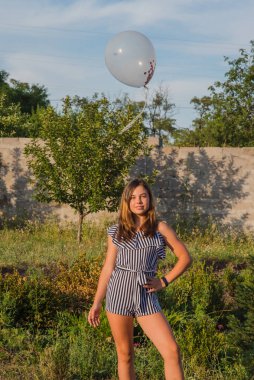 Güzel esmer bir kızın açık hava portresi. Esmer genç kız. Genç kız ve balonlar. Kız, balon, tatil, doğum günü. Hayattaki mutlu anlar. Kız 11-13 yaşlarında. Yaz tatili,
