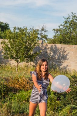 Güzel esmer bir kızın açık hava portresi. Esmer genç kız. Genç kız ve balonlar. Kız, balon, tatil, doğum günü. Hayattaki mutlu anlar. Kız 11-13 yaşlarında. Yaz tatili,