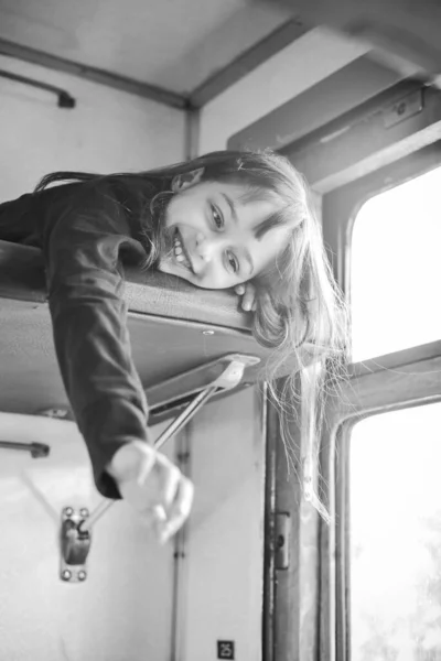 The girl rides a train in the summer on a trip. Vacation, train ride. A teenage girl rides a train. A school-age girl is lying on the top shelf in the train. Lifestyle