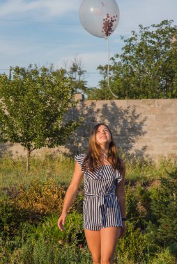 Güzel esmer bir kızın açık hava portresi. Esmer genç kız. Genç kız ve balonlar. Kız, balon, tatil, doğum günü. Hayattaki mutlu anlar. Kız 11-13 yaşlarında. Yaz tatili,