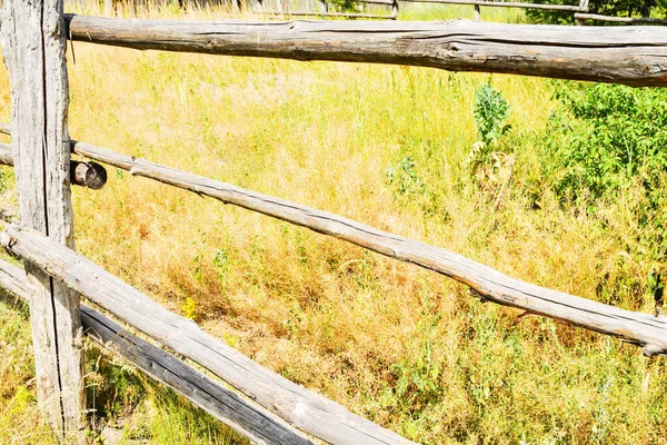 old wooden fence. Old fence on a background of grass. Fencing in the village. Ranch, farm