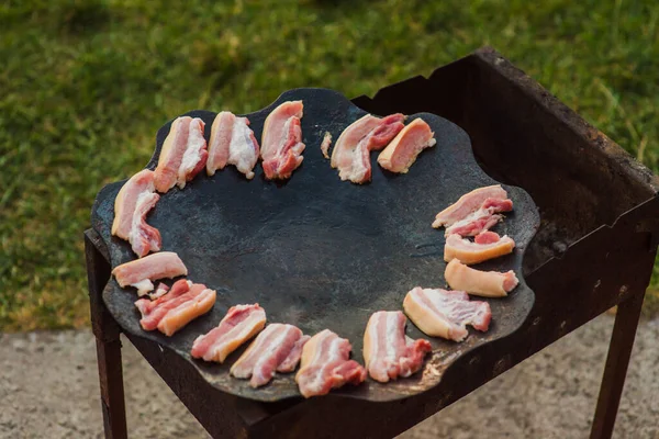 fried bacon. Bacon strips or rashers being cooked in frying pan. Bacon Sizzling on Skillet