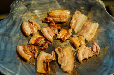 Kızarmış domuz. Pastırma şeritleri ya da kızartma tavasında pişen pastırmalar. Tavada jambon cızırtısı. Yemek fotoğrafçılığı