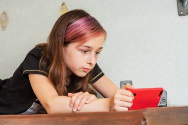 Trenle seyahat ederken akıllı telefon kullanan kız. Trendeki kız akıllı telefona bakmaktadır. Gençlik gereçleri tatil seyahati konsepti