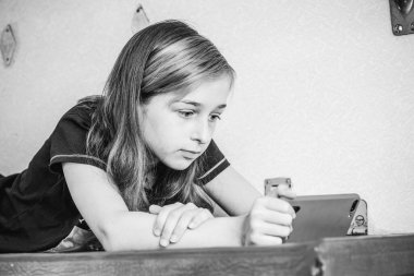 Trenle seyahat ederken akıllı telefon kullanan kız. Trendeki kız akıllı telefona bakmaktadır. Gençlik gereçleri tatil seyahati konsepti