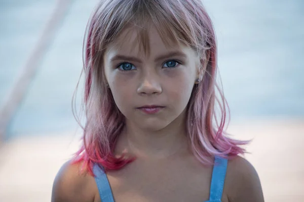 Sevimli kız portresi. Yaz gününde küçük şirin bir kızın açık hava portresi. Pembe saçlı küçük bir kızın portresi. Çocuk 7-8 yaşlarında. Ergen