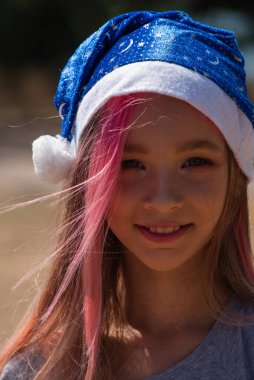 Noel Baba şapkalı mutlu küçük kız Noel 'i kutlar. Kırmızı Noel Baba şapkalı küçük kız. Noel Baba şapkalı kız.