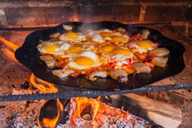 Yumurtalar sokakta ateşte kızarır. Pastırmalı sahanda yumurta. Fırındaki şenlik ateşinde bir tabak yumurta. Sokak yemeği. Yiyeceklerle dinlen. Tavada ızgara yumurta.