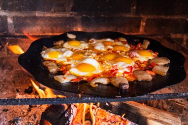 Yumurtalar sokakta ateşte kızarır. Pastırmalı sahanda yumurta. Fırındaki şenlik ateşinde bir tabak yumurta. Sokak yemeği. Yiyeceklerle dinlen. Tavada ızgara yumurta.