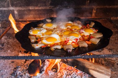 Yumurtalar sokakta ateşte kızarır. Pastırmalı sahanda yumurta. Fırındaki şenlik ateşinde bir tabak yumurta. Sokak yemeği. Yiyeceklerle dinlen. Tavada ızgara yumurta.