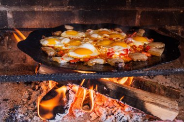 Yumurtalar sokakta ateşte kızarır. Pastırmalı sahanda yumurta. Fırındaki şenlik ateşinde bir tabak yumurta. Sokak yemeği. Yiyeceklerle dinlen. Tavada ızgara yumurta.