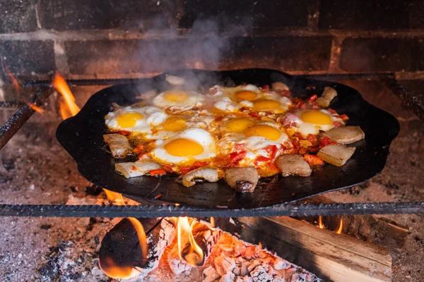 Yumurtalar sokakta ateşte kızarır. Pastırmalı sahanda yumurta. Fırındaki şenlik ateşinde bir tabak yumurta. Sokak yemeği. Yiyeceklerle dinlen. Tavada ızgara yumurta.