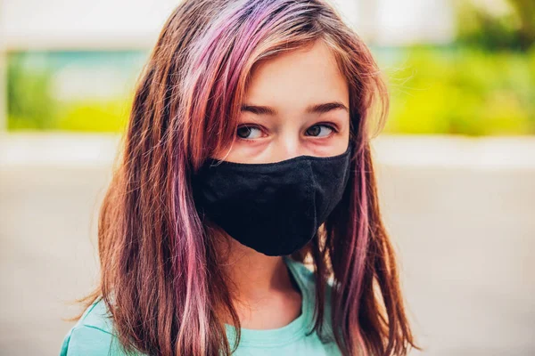 一个年轻的女孩戴着口罩 以防止考拉韦病的蔓延 穿着防病毒面具的青少年的衣服 外面戴着防护面具的女孩 大流行病 头孢病毒 — 图库照片