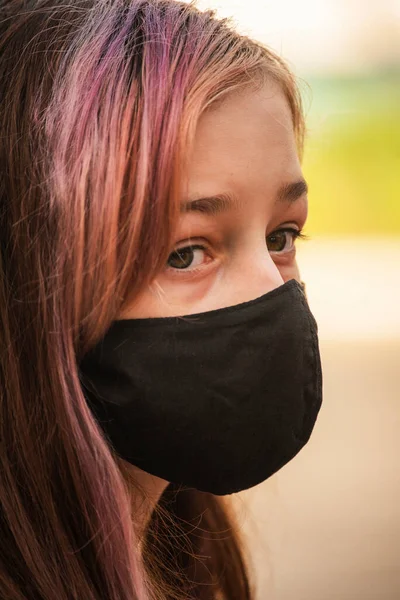 一个年轻的女孩戴着口罩 以防止考拉韦病的蔓延 穿着防病毒面具的青少年的衣服 外面戴着防护面具的女孩 大流行病 头孢病毒 — 图库照片