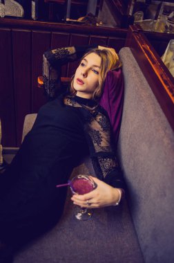 Meyveli buzlu güzel genç bayan. Kafede smoothie içen bir kız. Siyah elbiseli kız. Doğal saçlı bir kız. Kız ve kafede rahatlama, sağlıklı yiyecekler, vitaminler. Sakin kavram