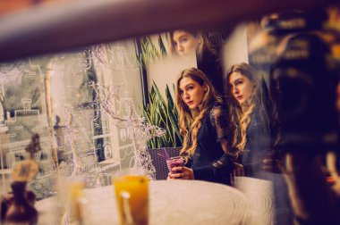 Meyveli buzlu güzel genç bayan. Kafede smoothie içen bir kız. Siyah elbiseli kız. Doğal saçlı bir kız. Kız ve kafede rahatlama, sağlıklı yiyecekler, vitaminler. Sakin kavram