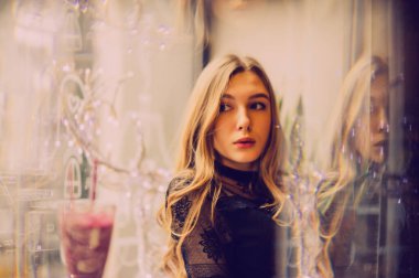 Meyveli buzlu güzel genç bayan. Kafede smoothie içen bir kız. Siyah elbiseli kız. Doğal saçlı bir kız. Kız ve kafede rahatlama, sağlıklı yiyecekler, vitaminler. Sakin kavram