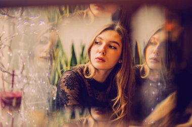 Meyveli buzlu güzel genç bayan. Kafede smoothie içen bir kız. Siyah elbiseli kız. Doğal saçlı bir kız. Kız ve kafede rahatlama, sağlıklı yiyecekler, vitaminler. Sakin kavram