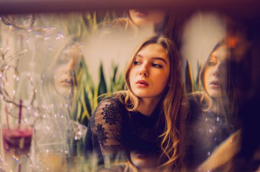 Meyveli buzlu güzel genç bayan. Kafede smoothie içen bir kız. Siyah elbiseli kız. Doğal saçlı bir kız. Kız ve kafede rahatlama, sağlıklı yiyecekler, vitaminler. Sakin kavram