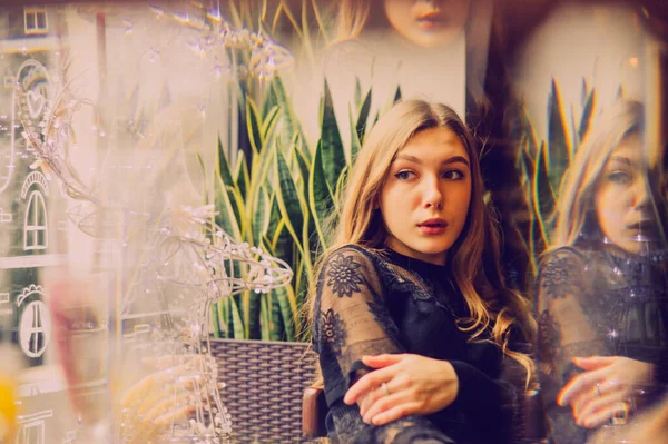 Meyveli buzlu güzel genç bayan. Kafede smoothie içen bir kız. Siyah elbiseli kız. Doğal saçlı bir kız. Kız ve kafede rahatlama, sağlıklı yiyecekler, vitaminler. Sakin kavram