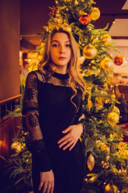 Bir kızın portresi. Lokantada tek başına siyah elbiseli zarif bir bayan. Kafedeki kız. Güzel bir kızın düşünceli ruh hali. İpek saçlı cesur bir genç kız. İnsanlar, moda, yaşam tarzı ve renk kavramı