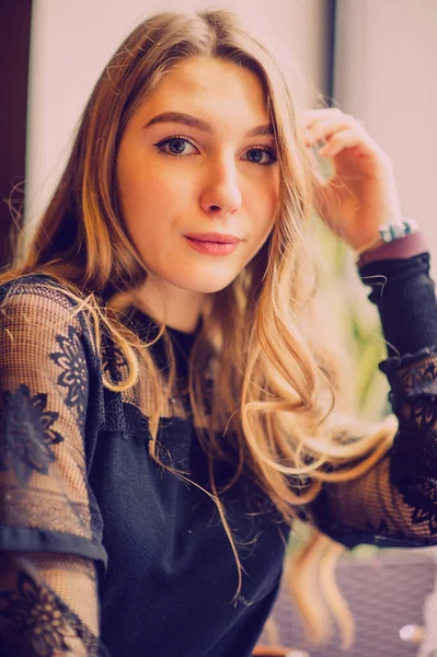 Bir kızın portresi. Lokantada tek başına siyah elbiseli zarif bir bayan. Kafedeki kız. Güzel bir kızın düşünceli ruh hali. İpek saçlı cesur bir genç kız. İnsanlar, moda, yaşam tarzı ve renk kavramı