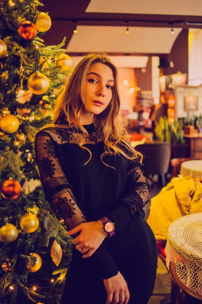 Bir kızın portresi. Lokantada tek başına siyah elbiseli zarif bir bayan. Kafedeki kız. Güzel bir kızın düşünceli ruh hali. İpek saçlı cesur bir genç kız. İnsanlar, moda, yaşam tarzı ve renk kavramı