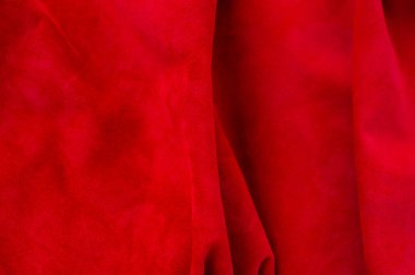 Süet kumaşın kırmızı mat arka planı, yakın plan. Dikensiz şarap derisinin kadife dokusu. Keçeleşmiş makro. Kırmızı doku