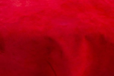 Süet kumaşın kırmızı mat arka planı, yakın plan. Dikensiz şarap derisinin kadife dokusu. Keçeleşmiş makro. Kırmızı doku