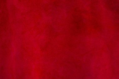 Süet kumaşın kırmızı mat arka planı, yakın plan. Dikensiz şarap derisinin kadife dokusu. Keçeleşmiş makro. Kırmızı doku