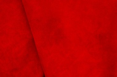 Süet kumaştan koyu kırmızı bir arka plan, yakın plan. Dikensiz şarap derisinin kadife dokusu. Keçeleşmiş makro. Kırmızı doku