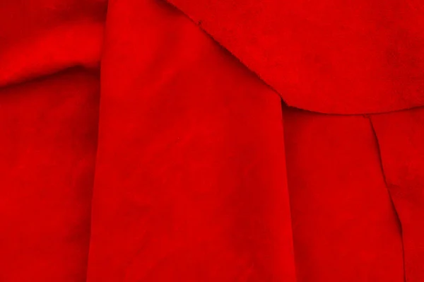 Dark red matte background of suede fabric, closeup. Velvet texture of seamless wine leather. Felt material macro. Red texture