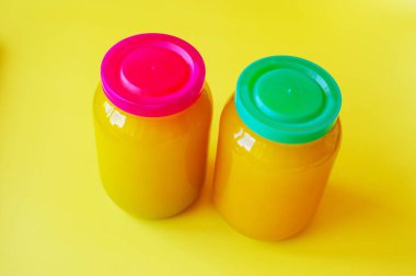 Sarı arka planda iki kavanoz bal. İki kavanoz bal. Sağlıklı yiyecekler, organik yiyecekler, beslenme, vejetaryen. Sarı arkaplanda izole edilmiş bal, yatay fotoğraf