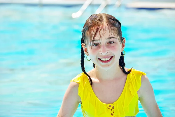 girl looking away while swimming in pool. excited girl looking away while swimming in pool. Joyful childhood. Relaxation concept. teenager. Girl laughing in a yellow bathing suit in the summer pool.