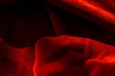 Süet kumaştan koyu kırmızı bir arka plan, yakın plan. Dikensiz şarap derisinin kadife dokusu. Keçeleşmiş makro. Kırmızı doku