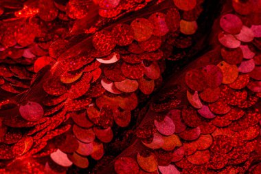 Kırmızı pullar. Pırıl pırıl pullar. Arka plan için kırmızı pullu kumaş. dikdörtgen kırmızı, pullu parlak kumaş, Noel arkaplanı. Dokuma sekansları, kırmızı boncuklar. Moda Kumaşı