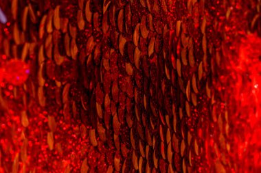 Kırmızı pullar. Pırıl pırıl pullar. Arka plan için kırmızı pullu kumaş. dikdörtgen kırmızı, pullu parlak kumaş, Noel arkaplanı. Dokuma sekansları, kırmızı boncuklar. Moda Kumaşı