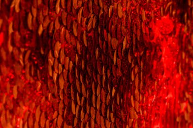 Kırmızı pullar. Pırıl pırıl pullar. Arka plan için kırmızı pullu kumaş. dikdörtgen kırmızı, pullu parlak kumaş, Noel arkaplanı. Dokuma sekansları, kırmızı boncuklar. Moda Kumaşı