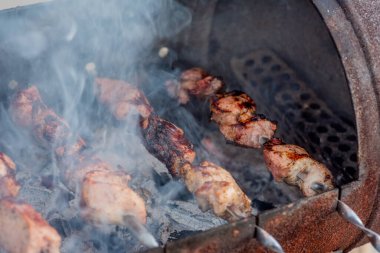 Metal şişte pişen ızgara kebap. Barbeküde pişmiş et. Barbekü taze et dilimleri. Geleneksel doğu yemeği, şiş kebap. Kömür ve alevler üzerine ızgara, piknik, sokak yemekleri