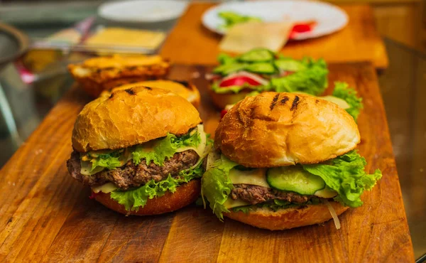 Tahta tahtada iki ev yapımı ızgara hamburger. Ev yapımı hamburgerler. Ev yapımı yemekler.